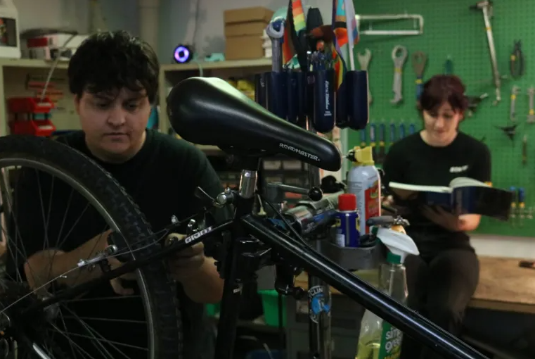 Two mechanics working on bicycles at RamBikes