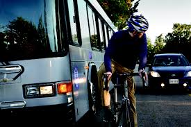 Man riding a bike next to a GRTC Bus